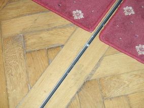 Obr. 9 – Detail podlahové štěrbiny rekonstruované parketové podlahy a koberců.