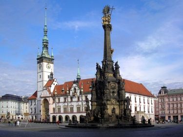 Obr. 1 – Radnice v Olomouci a sloup Nejsvětější Trojice zapsaný na seznamu UNESCO. Za balustrádou ve štítě proti malé věži je skrytý nasávací otvor vzduchotechniky, který není z žádného úhlu z Horního náměstí vidět.